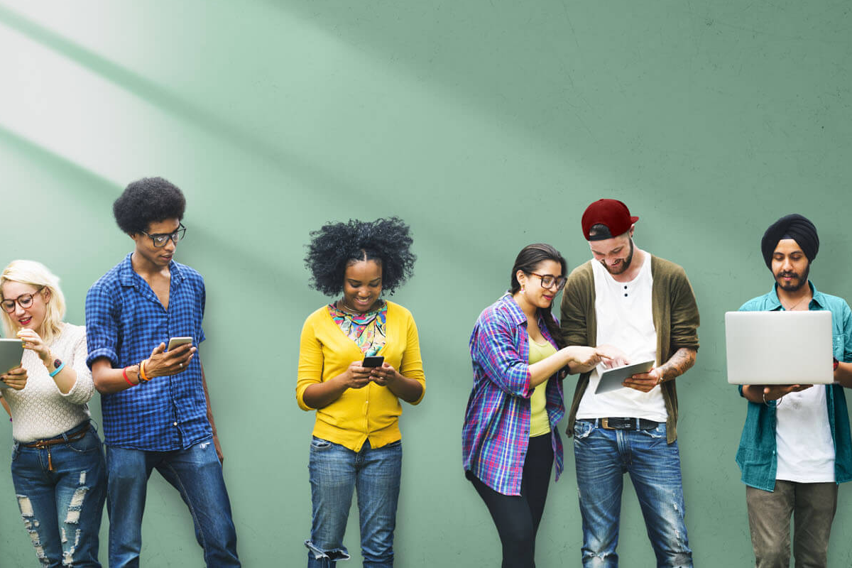 Un groupe diversifié d'hommes et de femmes sourient et utilisent la technologie sans fil pour collaborer en équipe.