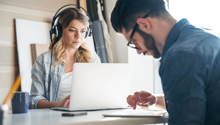 Une équipe d'hommes et de femmes travaillant ensemble dans un bureau, utilisant la technologie pour améliorer leur travail.