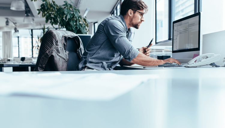 Un homme d'affaires masculin adulte travaille à l'intérieur avec la technologie.