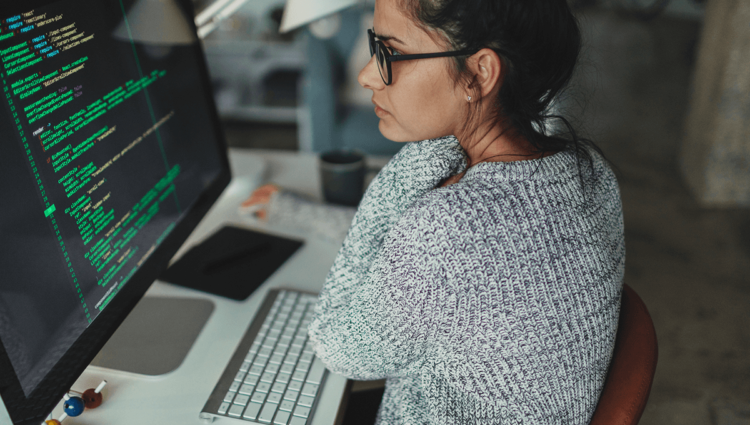 Une femme adulte travaille sur un ordinateur à l'intérieur d'un bureau, utilisant la technologie et internet.